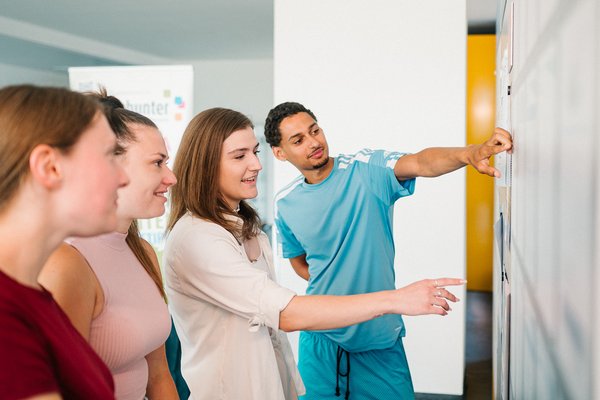 Studierende vor dem Infoboard.